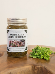 Original Chimichurri(non spicy) 16 oz jar, next to fresh parsley on wood block